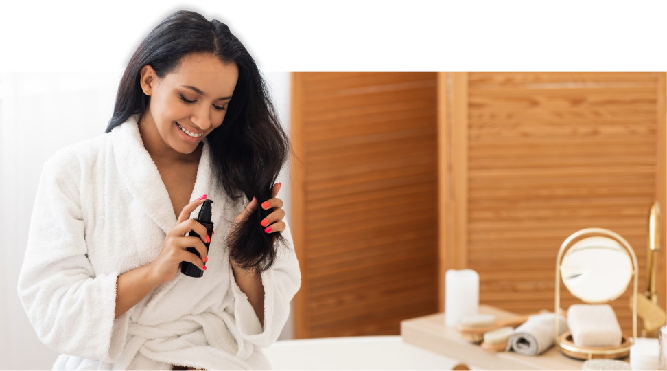 Mulher de roupão passando produto nos cabelos